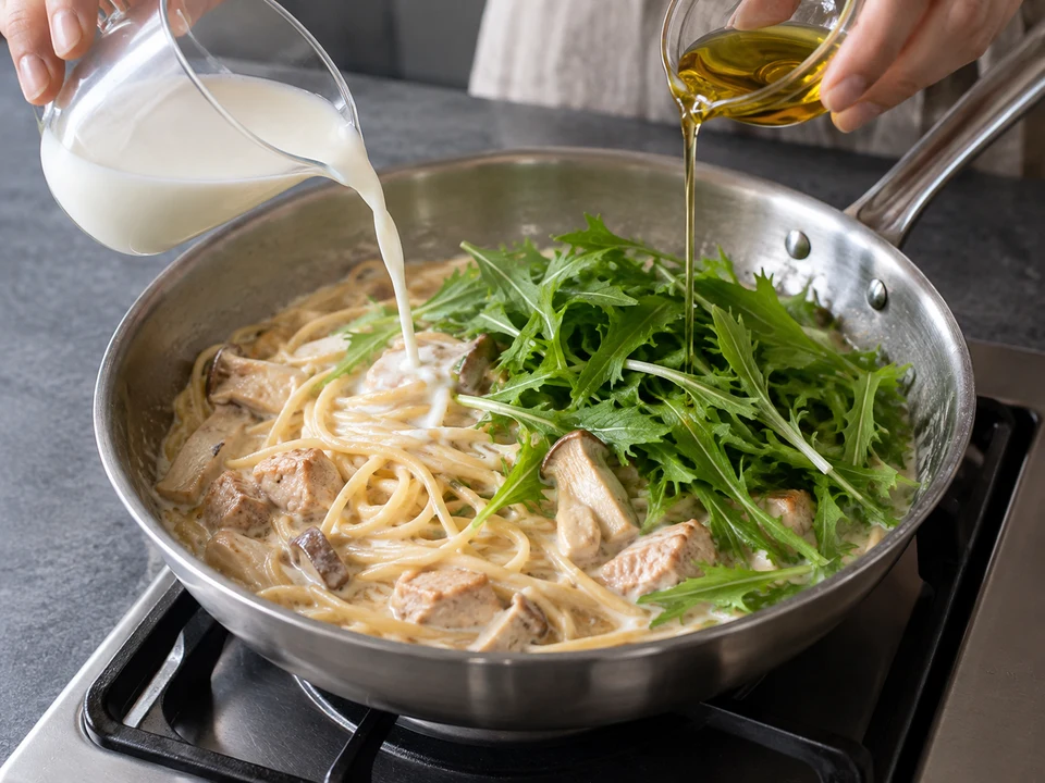 鶏肉のクリーム・スパゲッティー：牛乳と水菜をクリームパスタへ加えて火を止める手元。